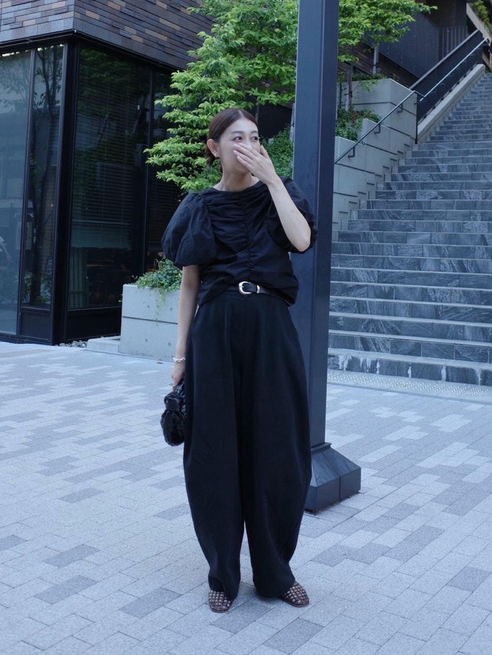 ブラック系のシャツ/ブラウス、ブラック系のチノパンツ、ブラウン系のバレエシューズを着用したレディースの秋コーディネートの2枚目の写真