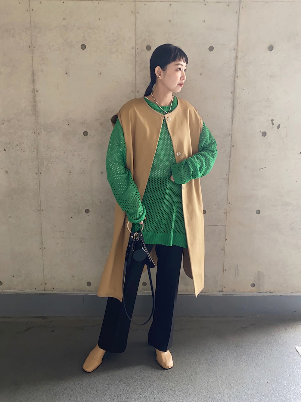 ベージュ系のその他アウター、グリーン系のニット/セーター、ブラック系のその他パンツを着用したレディースの春コーディネートの3枚目の写真