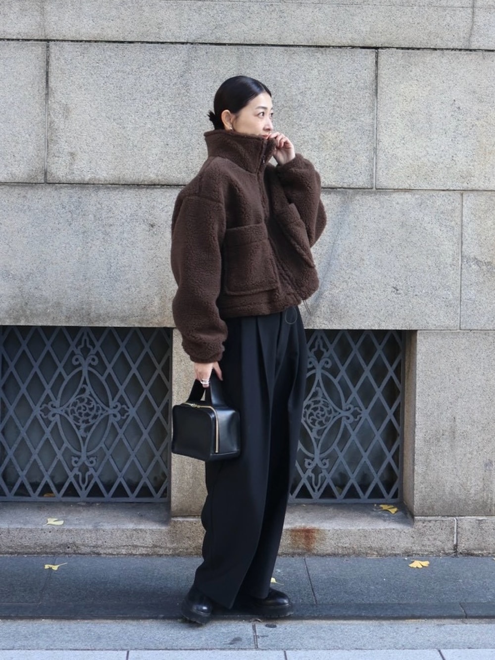 ブラウン系のその他アウター、ブラック系のスラックス、ブラック系のブーツを着用したレディースの冬コーディネートの3枚目の写真