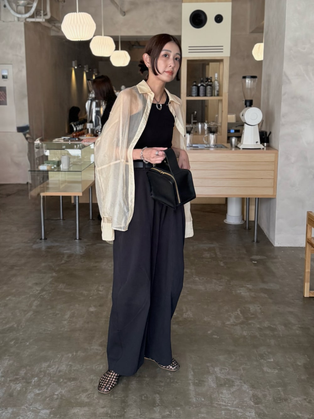 ブラック系のタンクトップ、ブラウン系のバレエシューズ、ブラック系のチノパンツを着用したレディースの秋コーディネートの2枚目の写真