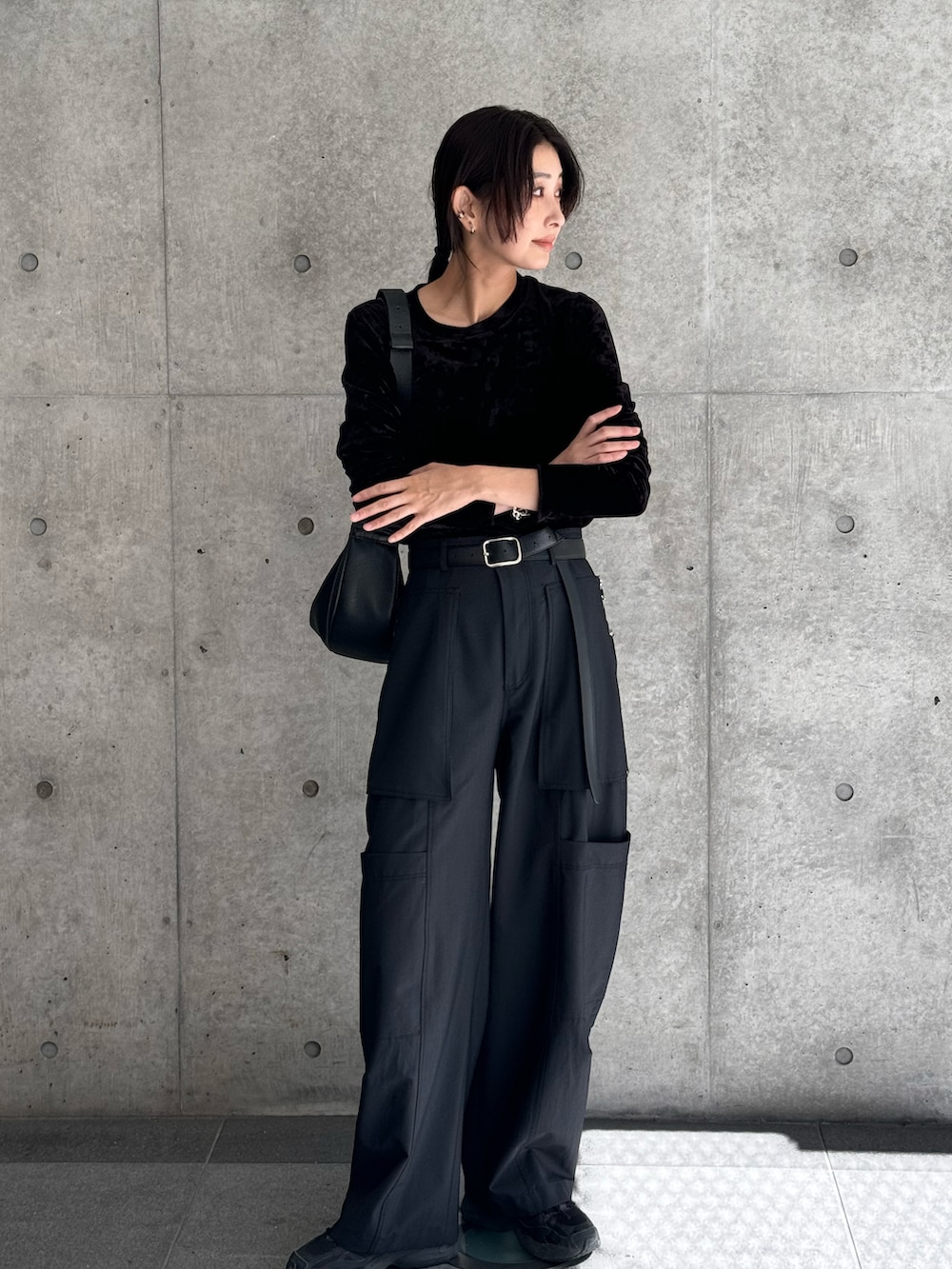 ブラック系のTシャツ/カットソー、ブラック系のショルダーバッグ、ブラック系のスニーカーを着用したレディースの秋コーディネートの5枚目の写真