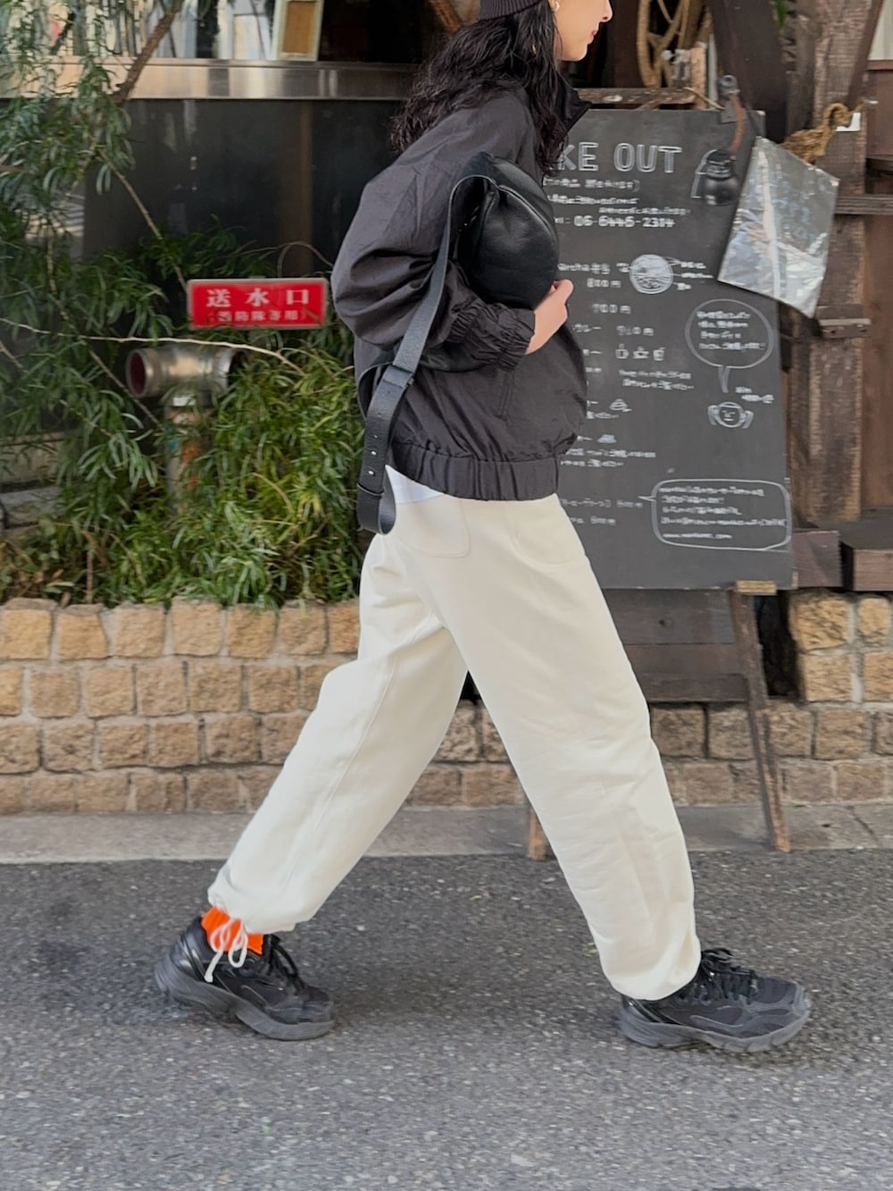 ブラック系のその他アウター、ブラック系のショルダーバッグ、ブラック系のスニーカーを着用したレディースの冬コーディネートの3枚目の写真