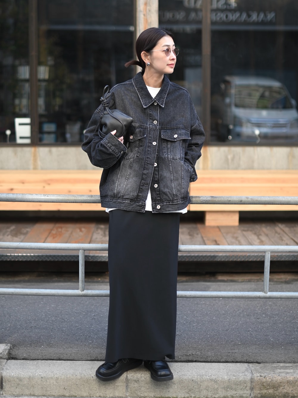 ブラック系のデニムジャケット、ブラック系のスカート、ブラック系のローファーを着用したレディースの春コーディネートの5枚目の写真