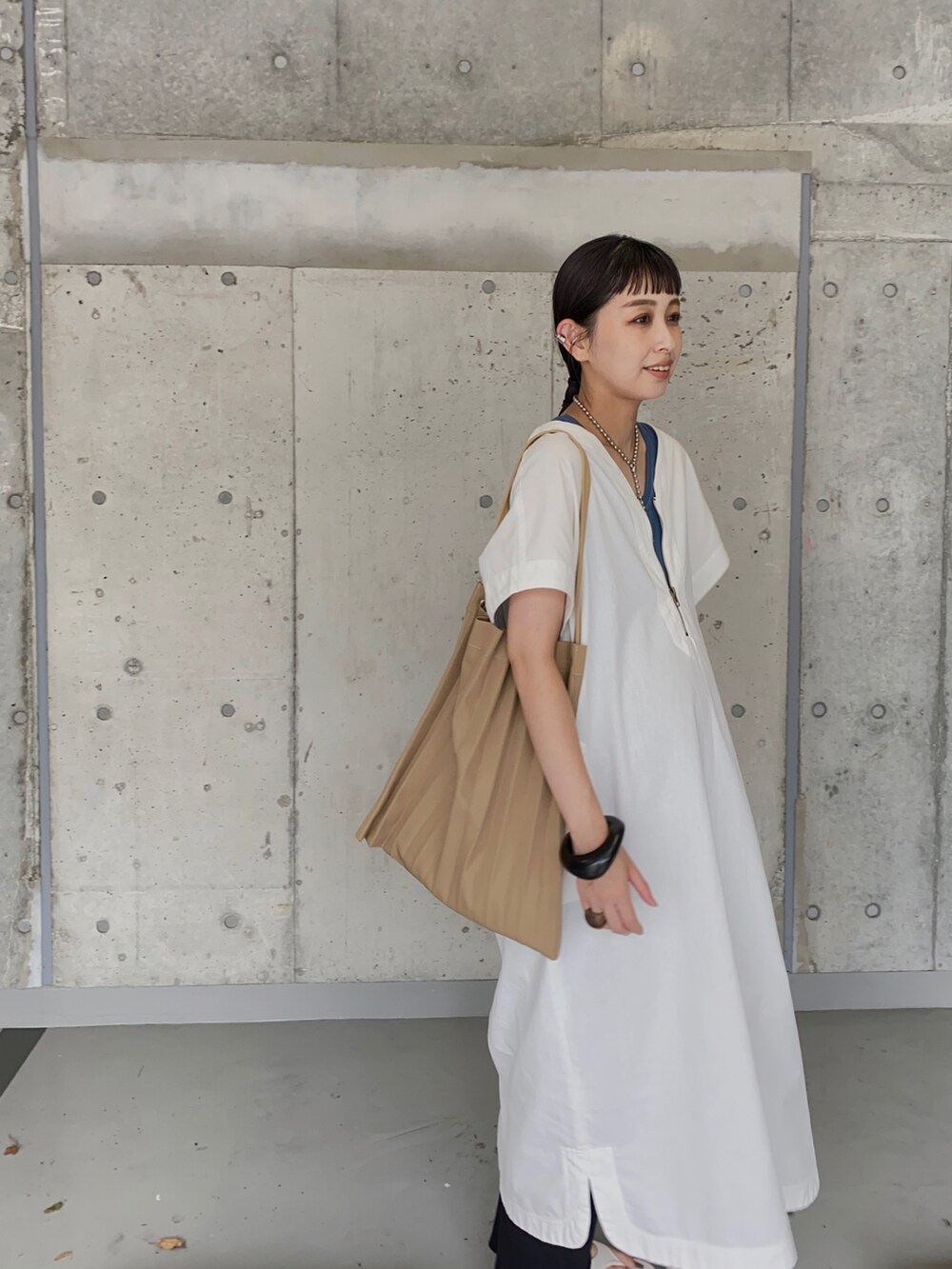 ホワイト系のワンピース、ブルー系のタンクトップ、ホワイト系のサンダルを着用したレディースの夏コーディネートの3枚目の写真