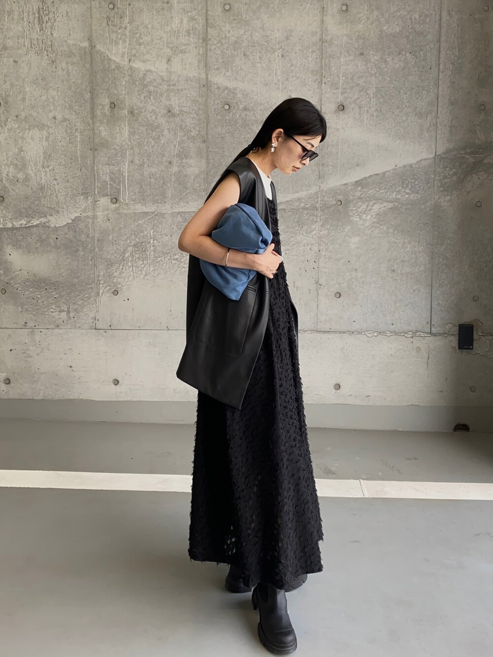 ブラック系のベスト、ブラック系のワンピース、ブラック系のブーツを着用したレディースの秋コーディネートの3枚目の写真