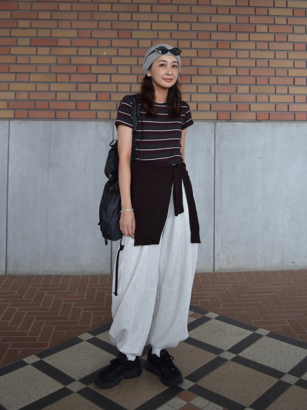 ブラック系のスウェットパンツ、グレー系のTシャツ/カットソー、ブラウン系のカーディガン/ボレロを着用したレディースの秋コーディネートの2枚目の写真