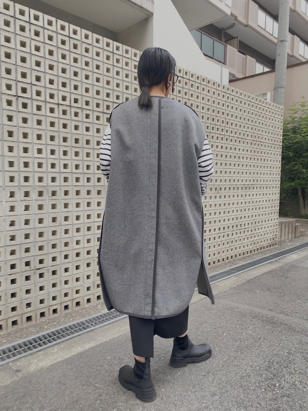 グレー系のその他アウター、ホワイト系のTシャツ/カットソー、ブラック系のハンドバッグを着用したレディースの秋コーディネートの2枚目の写真