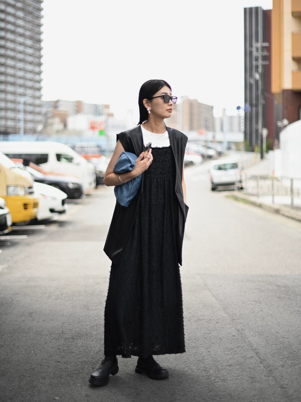 ブラック系のベスト、ブラック系のワンピース、ブラック系のブーツを着用したレディースの秋コーディネートの2枚目の写真