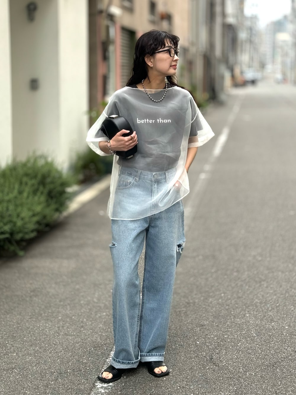 ホワイト系のシャツ/ブラウス、ブルー系のデニムパンツ、ブラック系のハンドバッグを着用したレディースの春コーディネートの2枚目の写真