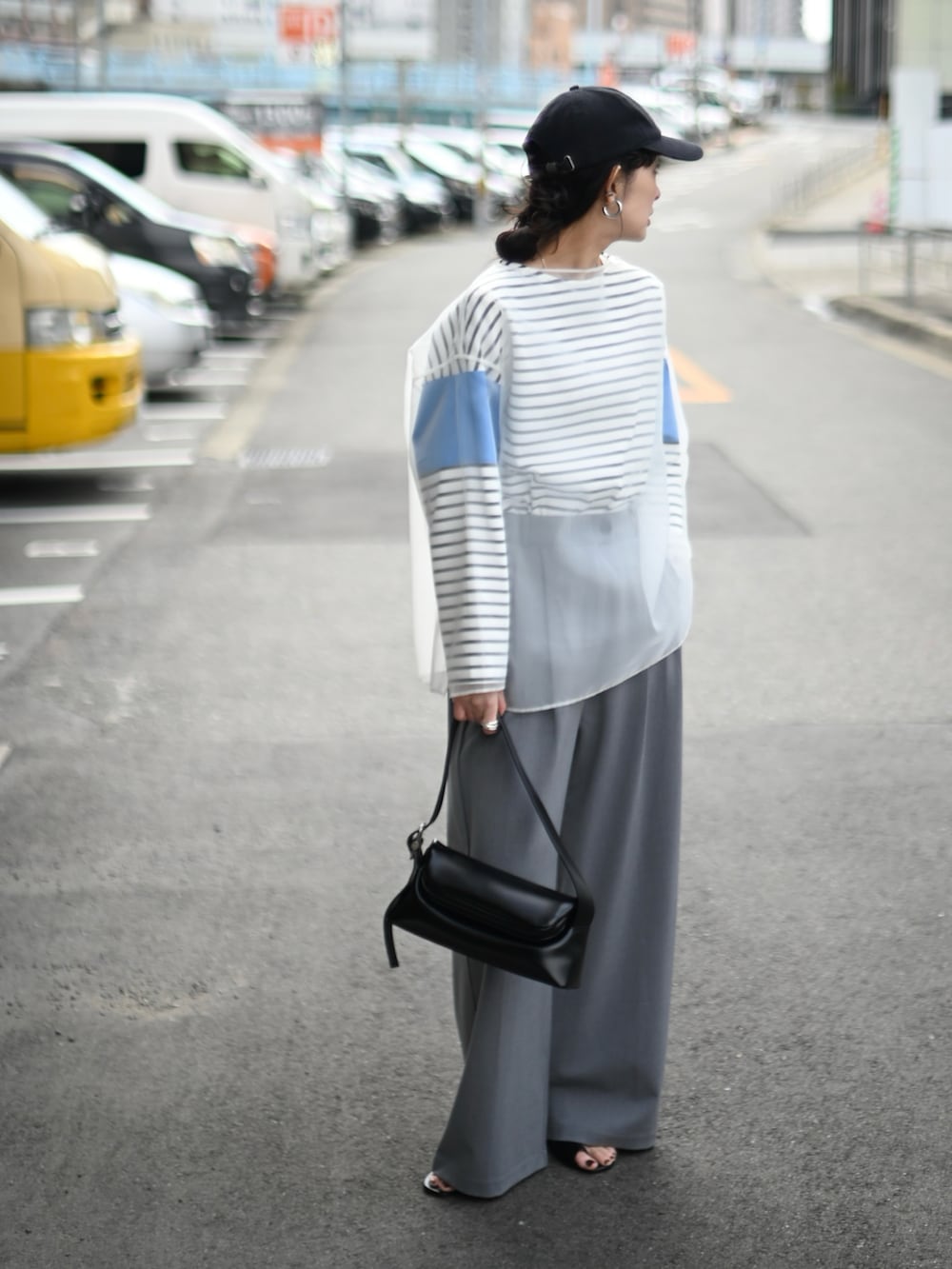 ホワイト系のシャツ/ブラウス、ブルー系のTシャツ/カットソー、ブラック系のショルダーバッグを着用したレディースの春コーディネートの5枚目の写真