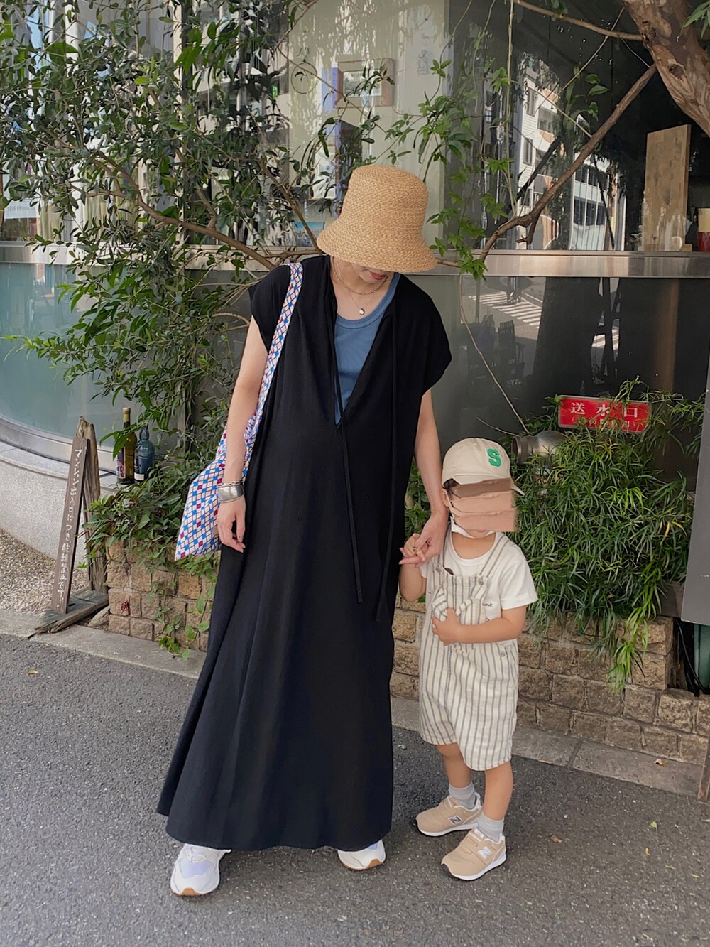 ブラック系のワンピース、ホワイト系のスニーカー、ブルー系のタンクトップを着用したレディースの秋コーディネートの3枚目の写真