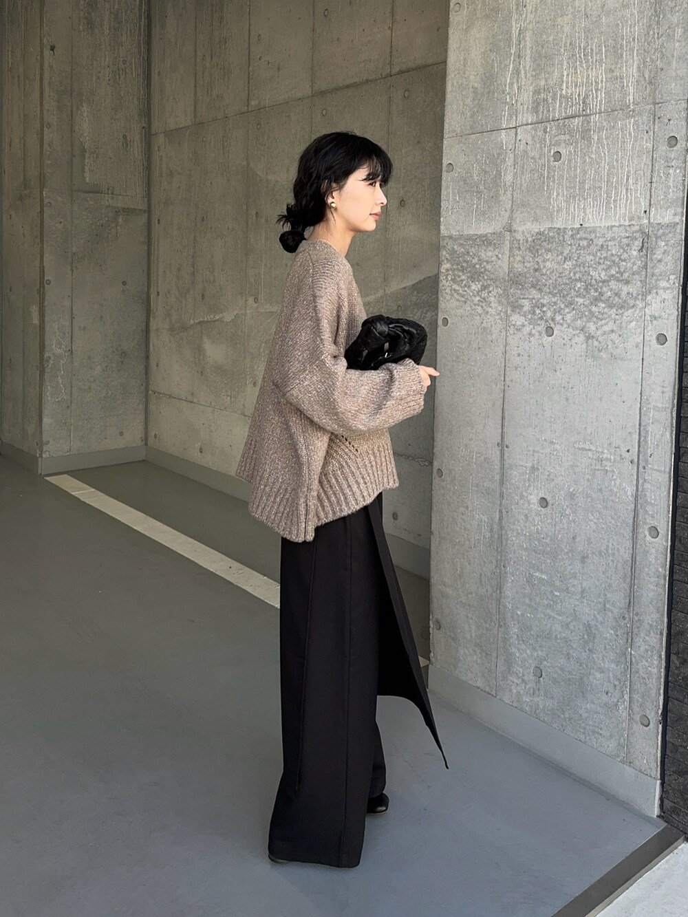 ベージュ系のカーディガン/ボレロ、ブラック系のスラックス、ブラック系のブーツを着用したレディースの冬コーディネートの2枚目の写真