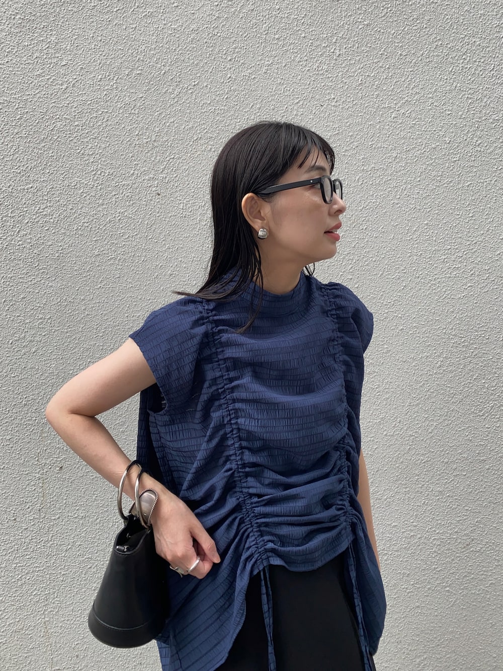 ブルー系のシャツ/ブラウス、ブラック系のスカート、ブラック系のサンダルを着用したレディースの夏コーディネートの3枚目の写真