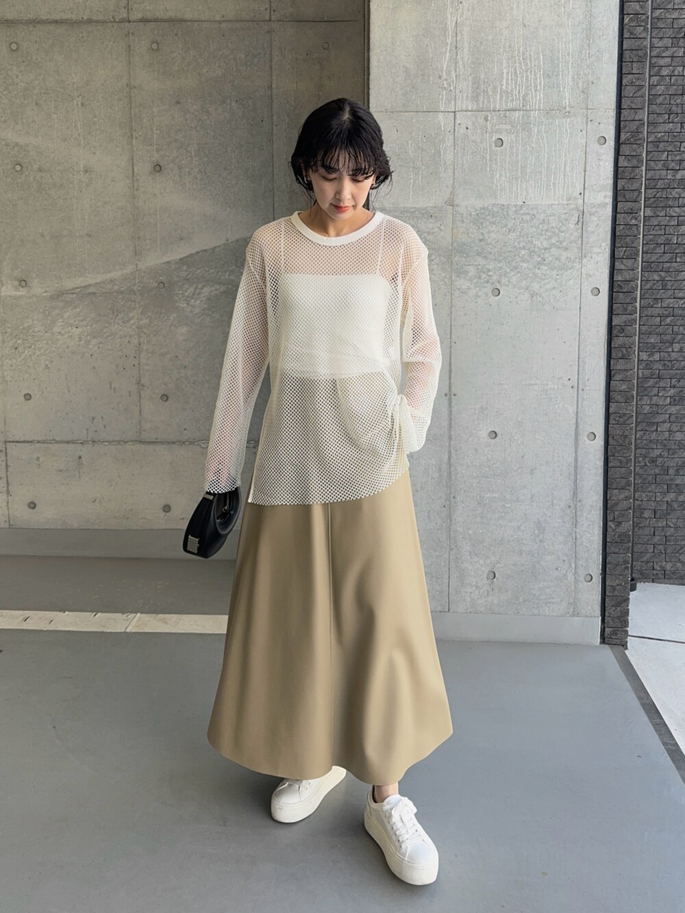 ホワイト系のTシャツ/カットソー、ホワイト系のスニーカー、ブラック系のハンドバッグを着用したレディースの夏コーディネートの2枚目の写真