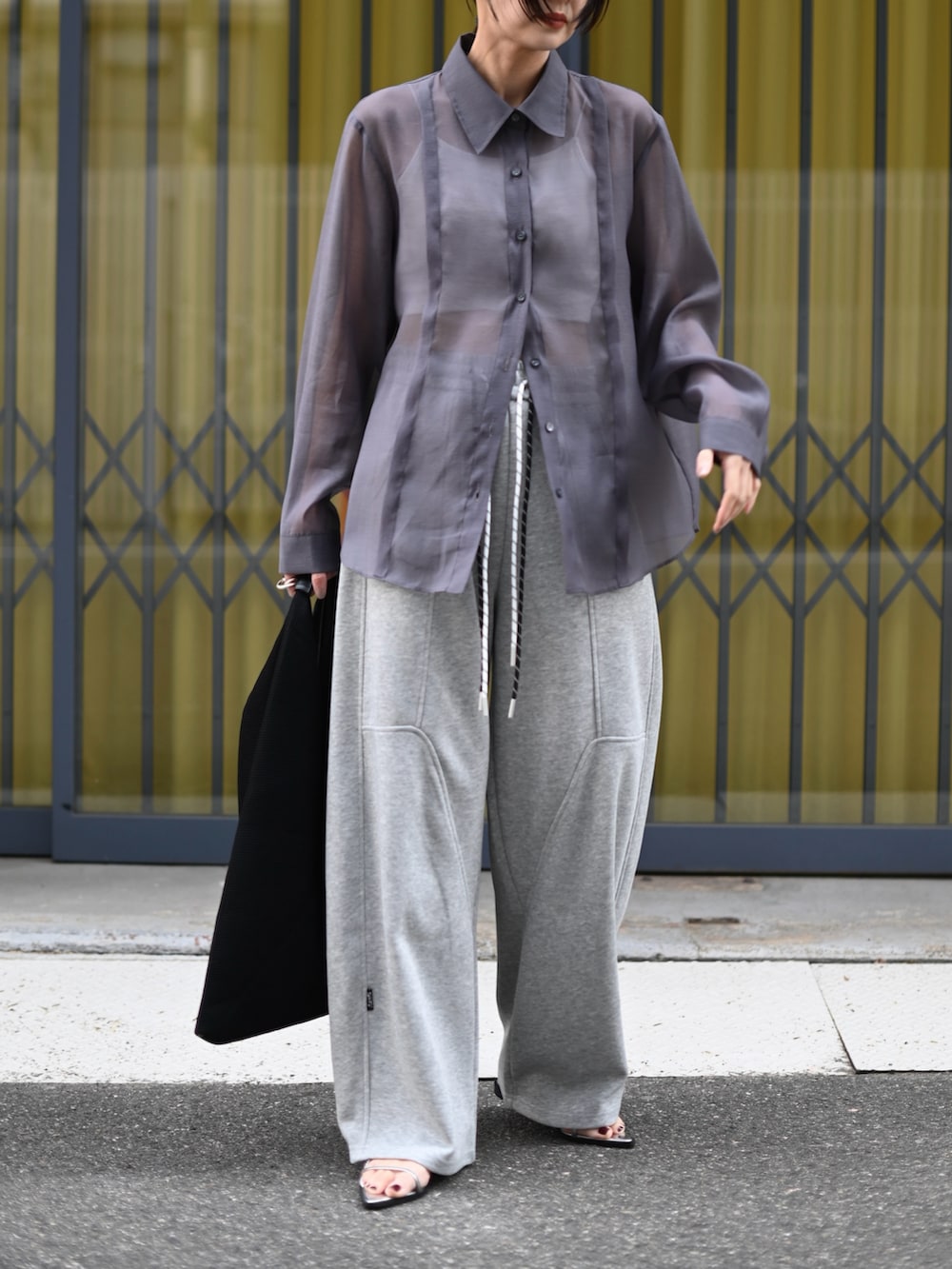 グレー系のシャツ/ブラウス、グレー系のスウェットパンツ、ブラック系のハンドバッグを着用したレディースの夏コーディネートの3枚目の写真
