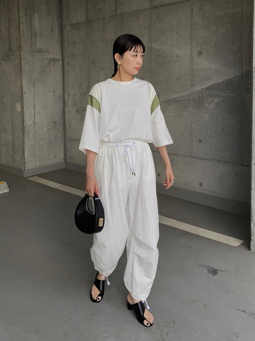 ホワイト系のTシャツ/カットソー、ホワイト系のその他パンツ、ブラック系のハンドバッグを着用したレディースの夏コーディネートの3枚目の写真