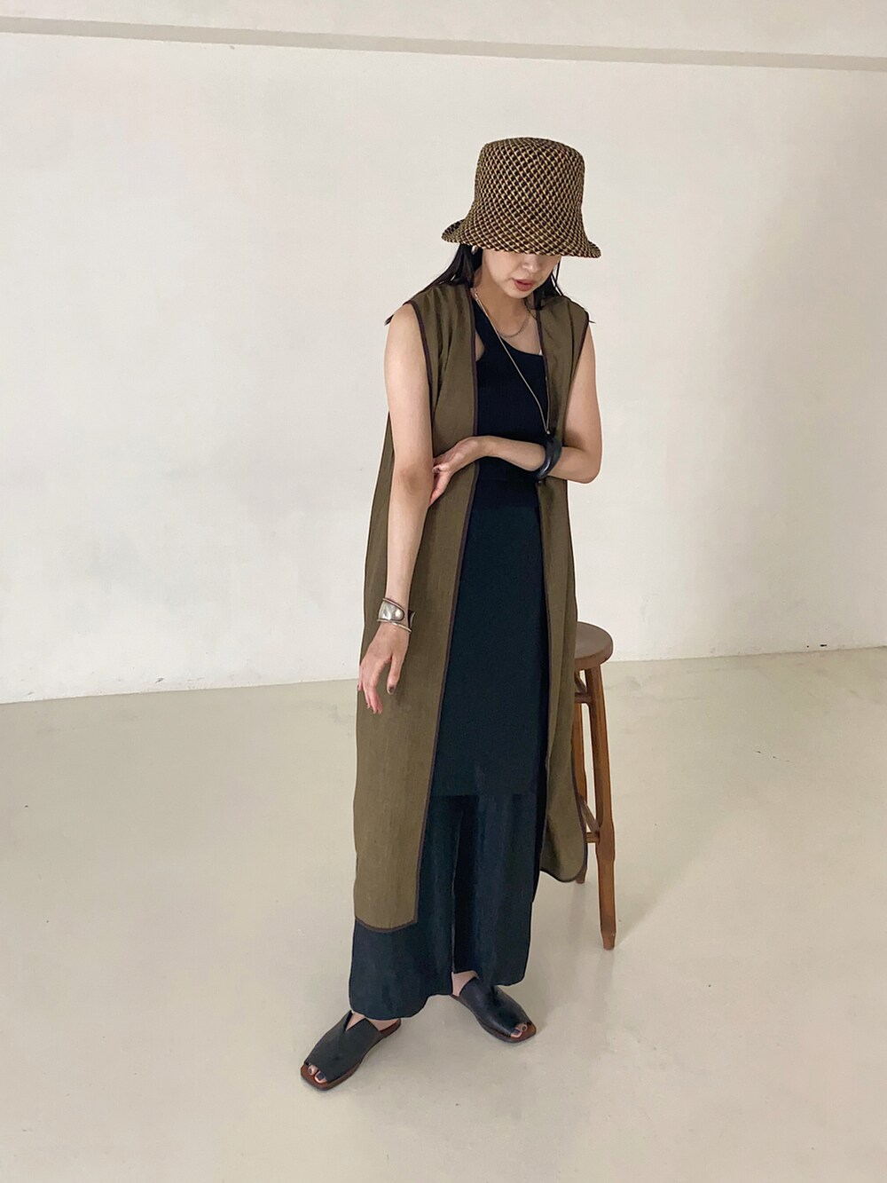 ブラック系のニット/セーター、ブラウン系のジャケット/アウター、ブラック系のハットを着用したレディースの夏コーディネートの2枚目の写真