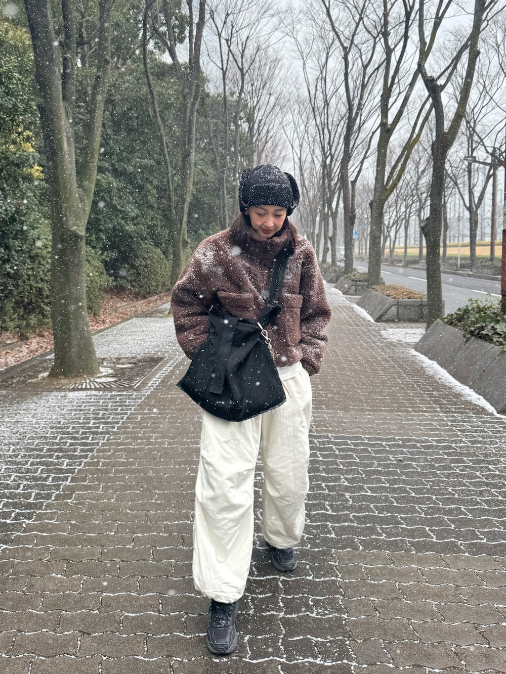 ブラウン系のその他アウター、ブラック系のトートバッグ、ホワイト系のその他パンツを着用したレディースの冬コーディネートの4枚目の写真