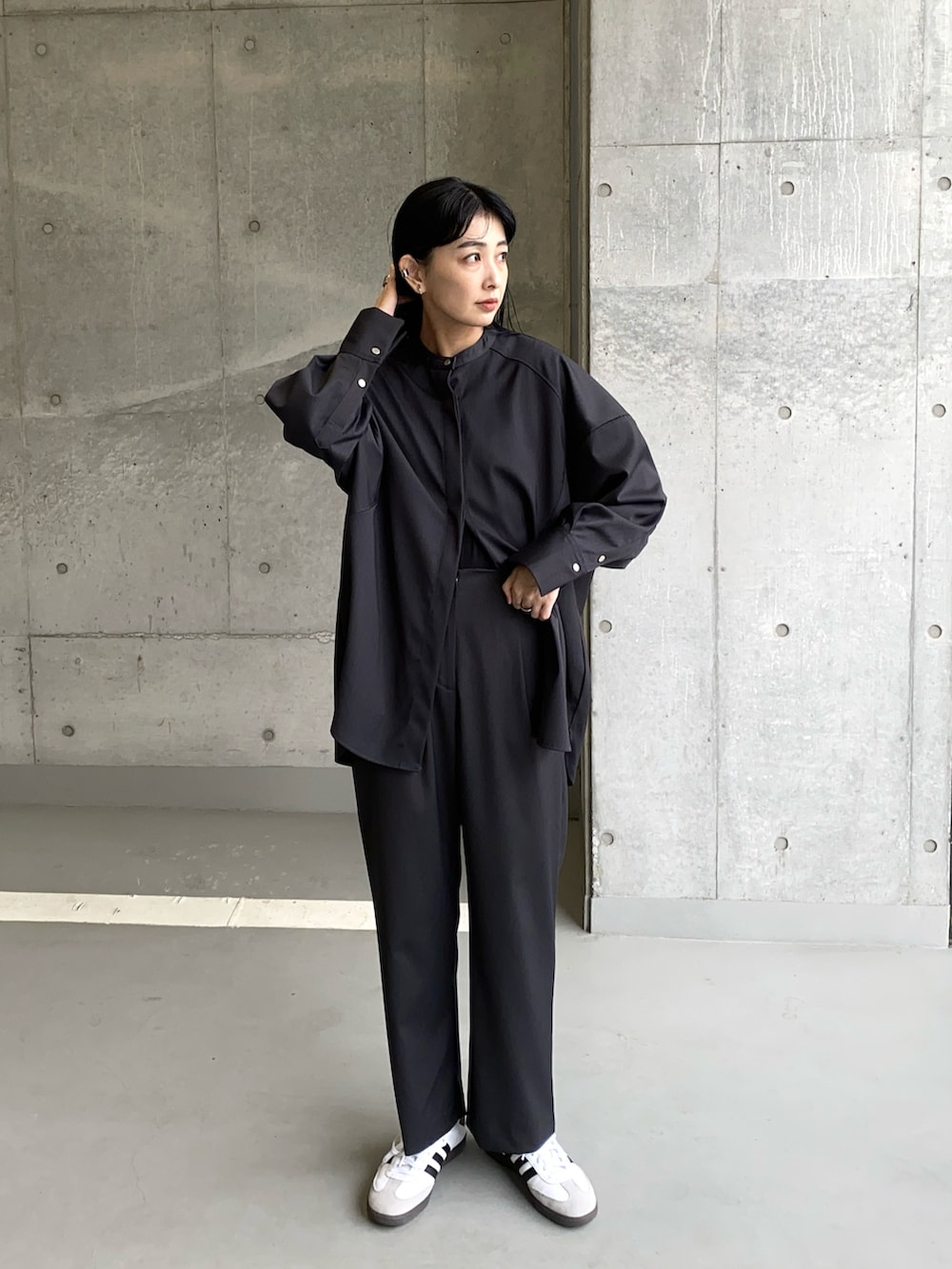 グレー系のシャツ/ブラウス、グレー系のスラックス、ホワイト系のスニーカーを着用したレディースの冬コーディネートの2枚目の写真