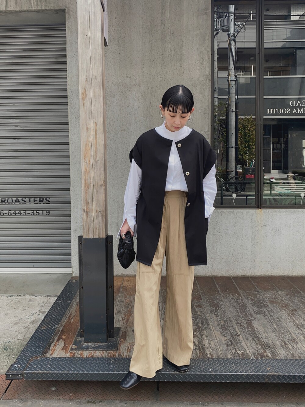 ブラック系のベスト、ホワイト系のシャツ/ブラウス、ベージュ系のカーゴパンツを着用したレディースの春コーディネートの2枚目の写真