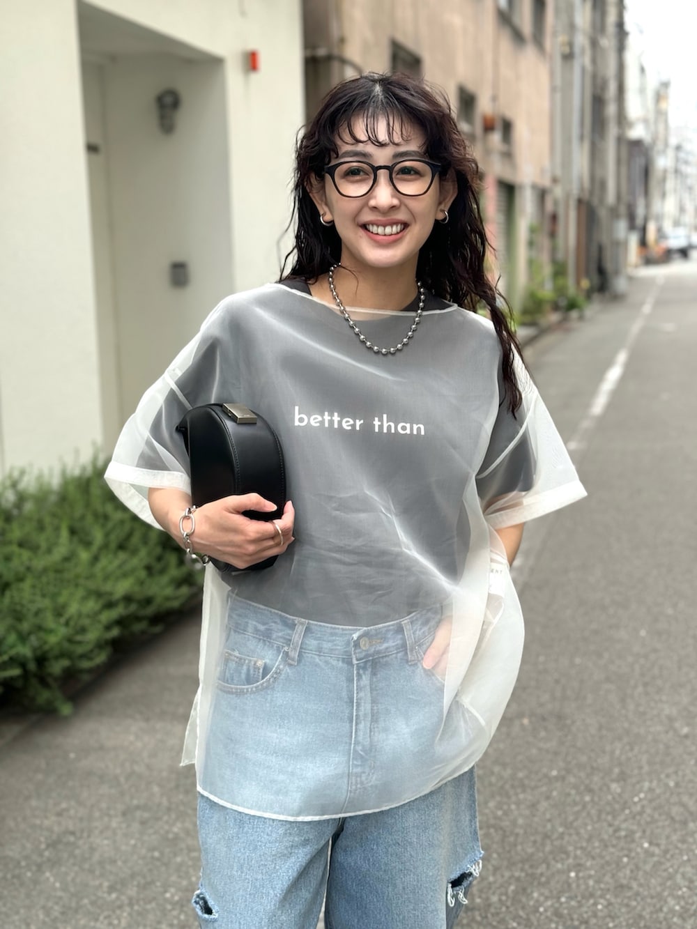 ホワイト系のシャツ/ブラウス、ブルー系のデニムパンツ、ブラック系のハンドバッグを着用したレディースの春コーディネートの3枚目の写真