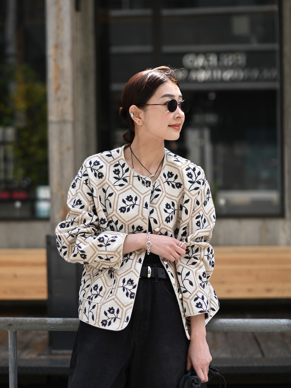 ブラック系のデニムパンツ、ブラック系のチューブトップ、ベージュ系のノーカラージャケットを着用したレディースの春コーディネートの3枚目の写真