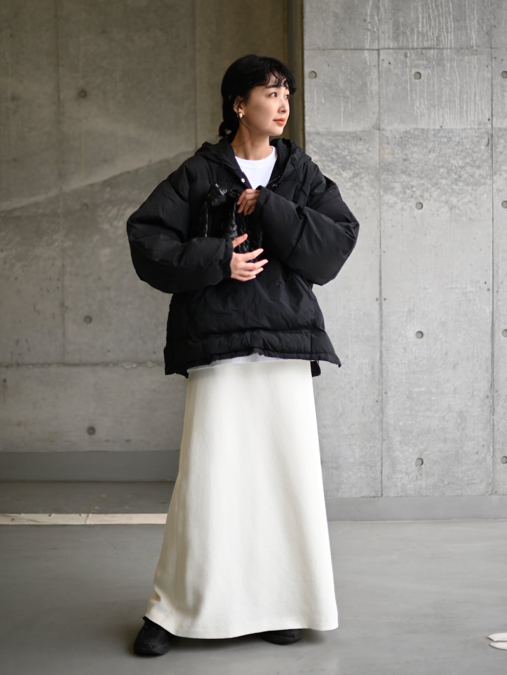 ブラック系のダウンジャケット/コート、ブラック系のスニーカーを着用したレディースの冬コーディネートの2枚目の写真