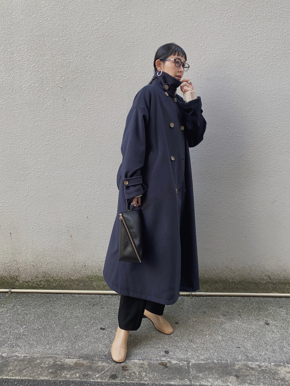 ブルー系のステンカラーコート、ブラック系のメガネを着用したレディースの冬コーディネートの3枚目の写真