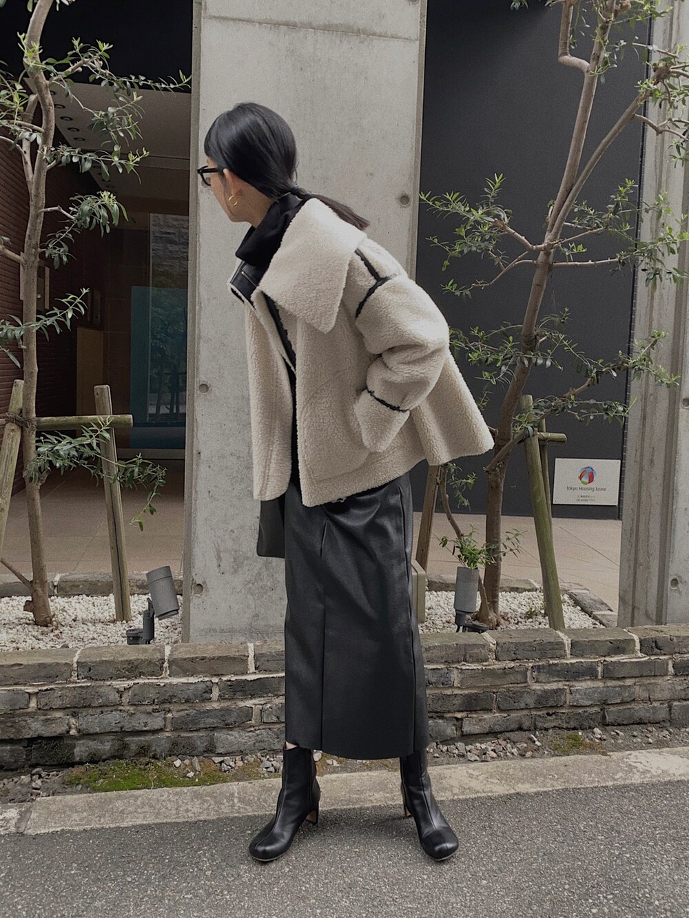 ブラック系のニット/セーター、ブラック系のブーツ、ブラック系のその他アウターを着用したレディースの秋コーディネートの3枚目の写真