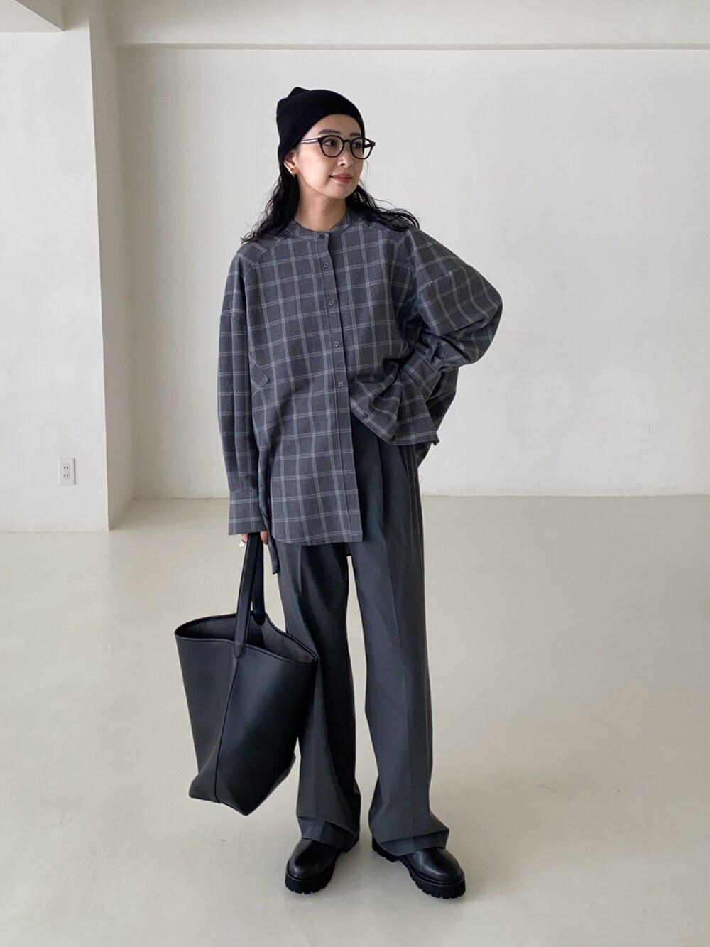 グレー系のシャツ/ブラウス、グレー系のスラックス、ブラック系のショルダーバッグを着用したレディースの秋コーディネートの2枚目の写真