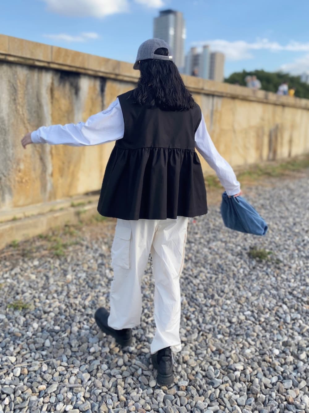 ホワイト系のTシャツ/カットソー、ホワイト系のカーゴパンツ、ブラック系のその他アウターを着用したレディースの秋コーディネートの4枚目の写真