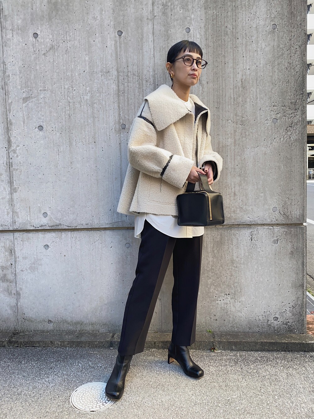 ブラック系のその他アウター、ホワイト系のシャツ/ブラウス、ゴールド系のイヤリングを着用したレディースの冬コーディネートの4枚目の写真