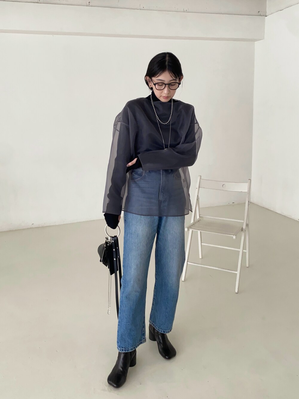 グレー系のシャツ/ブラウス、ブラック系のニット/セーター、ブラック系のショルダーバッグを着用したレディースの秋コーディネートの3枚目の写真