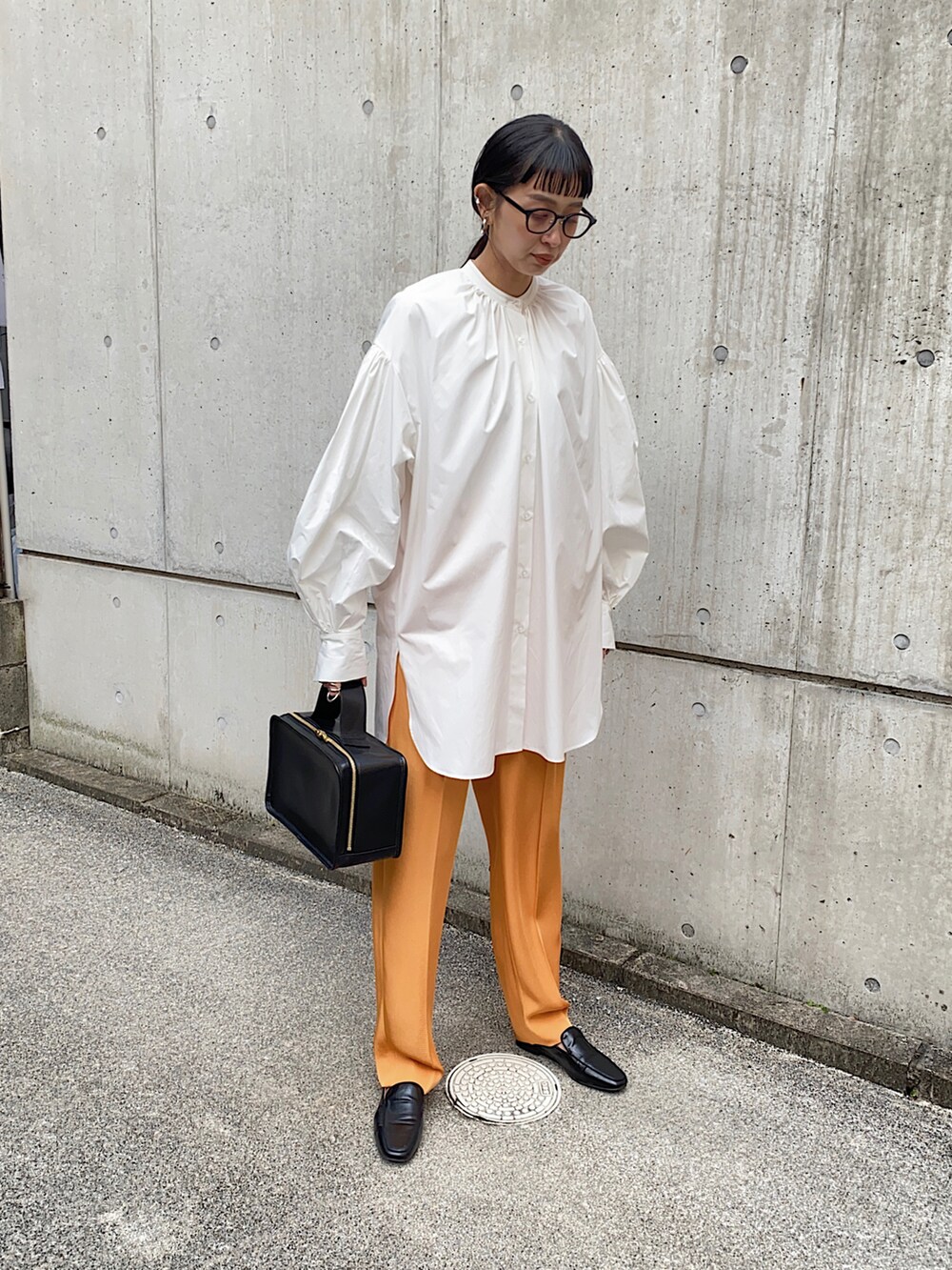 ホワイト系のシャツ/ブラウス、オレンジ系のその他パンツ、ブラック系のローファーを着用したレディースの春コーディネートの3枚目の写真