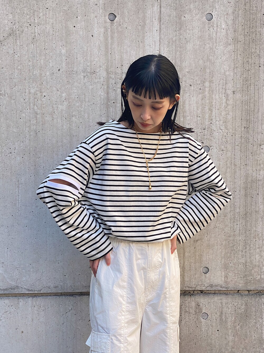 ブラック系のTシャツ/カットソー、ホワイト系のその他パンツ、ブラック系のショルダーバッグを着用したレディースの春コーディネートの2枚目の写真