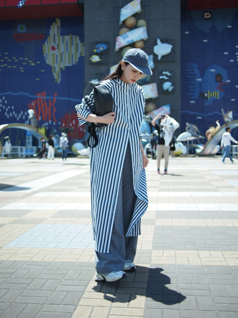 その他のシャツワンピース、グレー系のスラックス、ホワイト系のスニーカーを着用したレディースの春コーディネートの2枚目の写真