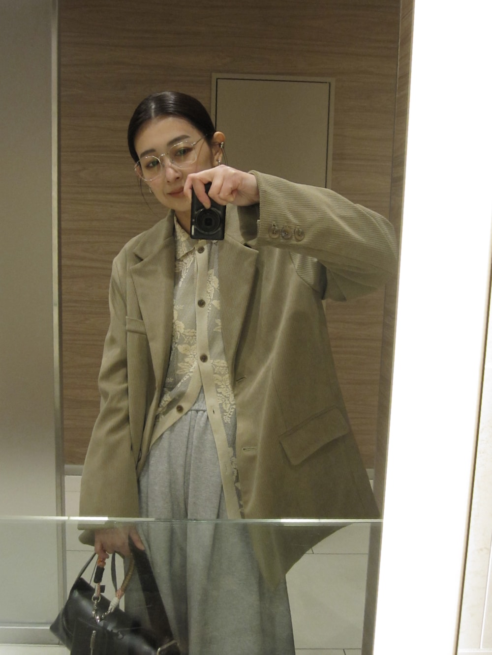 ベージュ系のテーラードジャケット、ブラック系のショルダーバッグ、グレー系のスウェットパンツを着用したレディースの春コーディネートの4枚目の写真