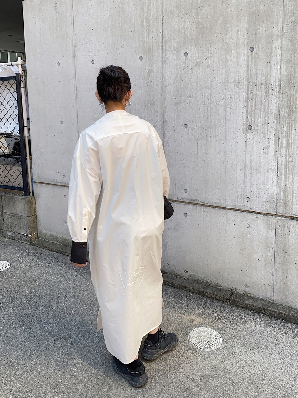 ホワイト系のシャツワンピース、ブラック系のショルダーバッグを着用したレディースの秋コーディネートの2枚目の写真