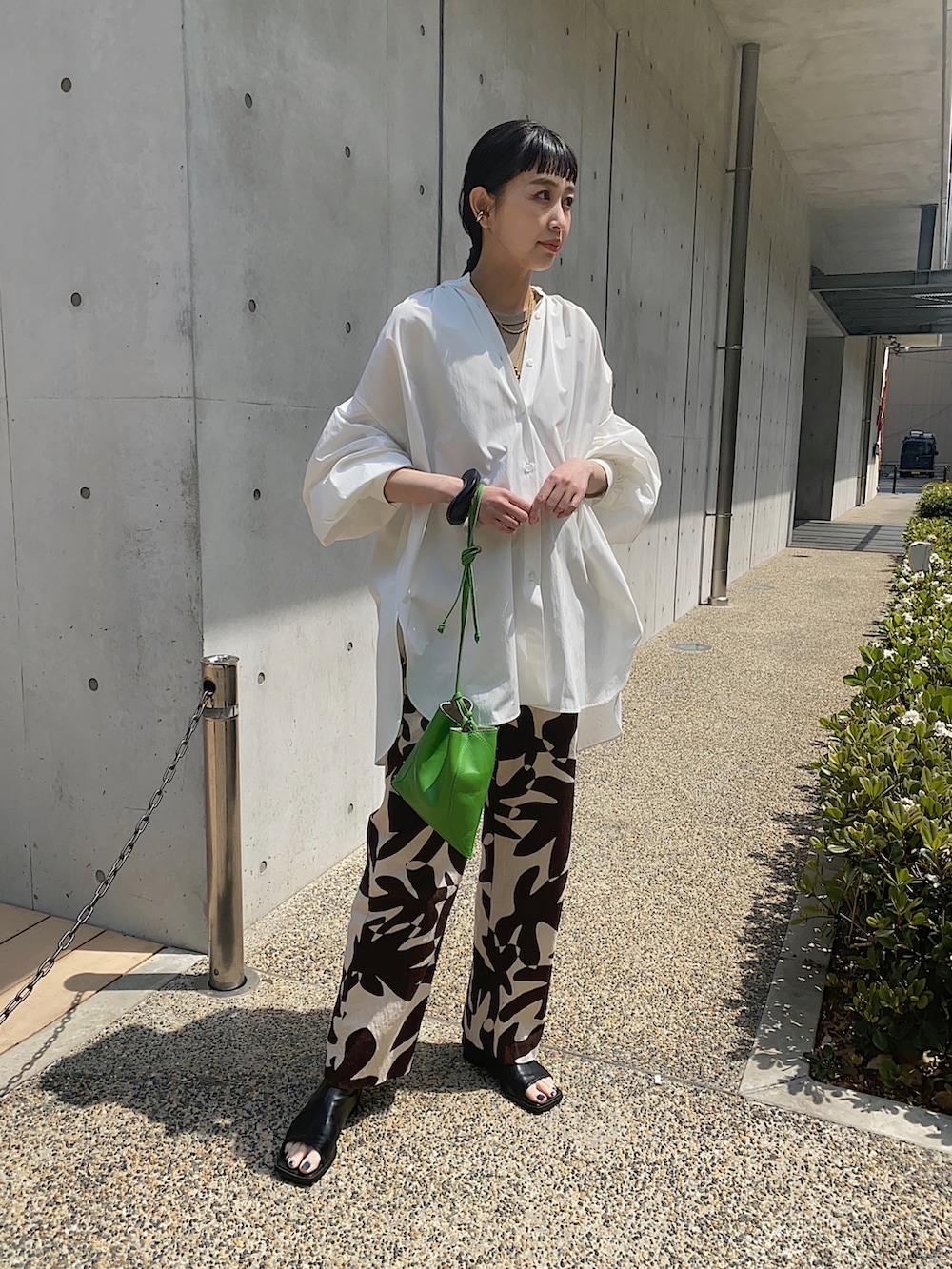 ホワイト系のシャツ/ブラウス、グリーン系のハンドバッグ、ブラック系のブレスレットを着用したレディースの春コーディネートの3枚目の写真