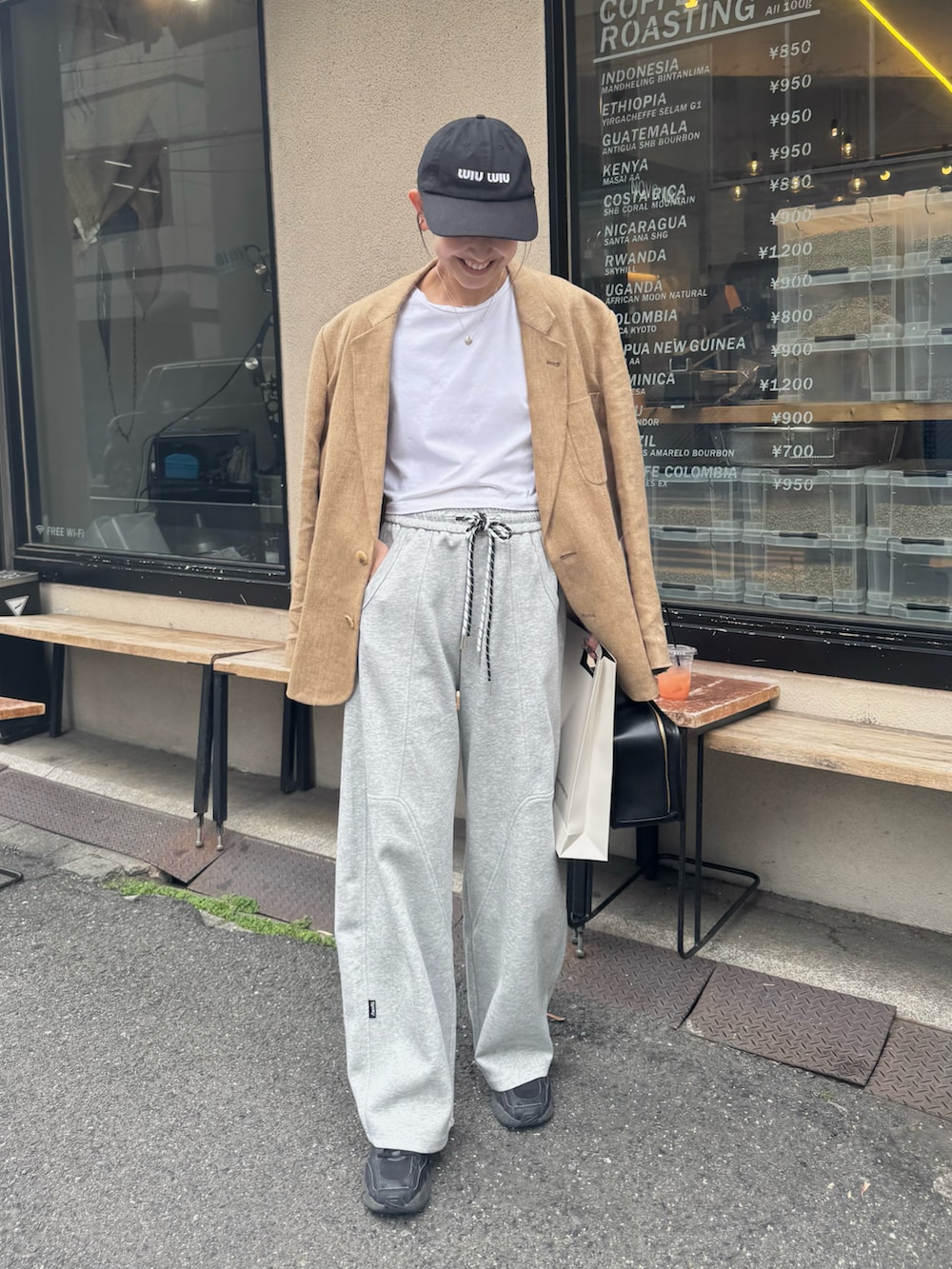 グレー系のスウェットパンツ、ブラック系のスニーカー、ベージュ系のテーラードジャケットを着用したレディースの春コーディネートの2枚目の写真