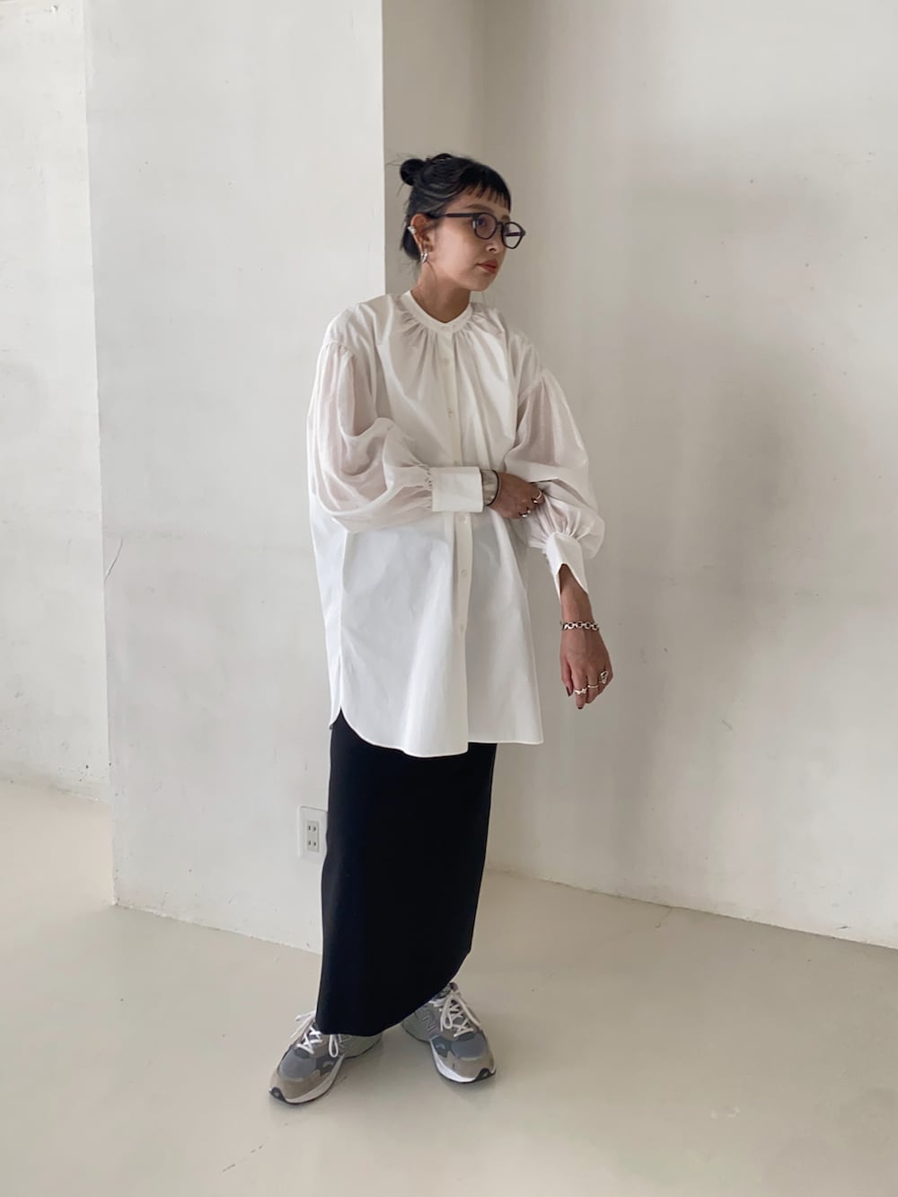 ブラック系のシャツ/ブラウス、ブラック系のスカート、グレー系のスニーカーを着用したレディースの秋コーディネートの3枚目の写真