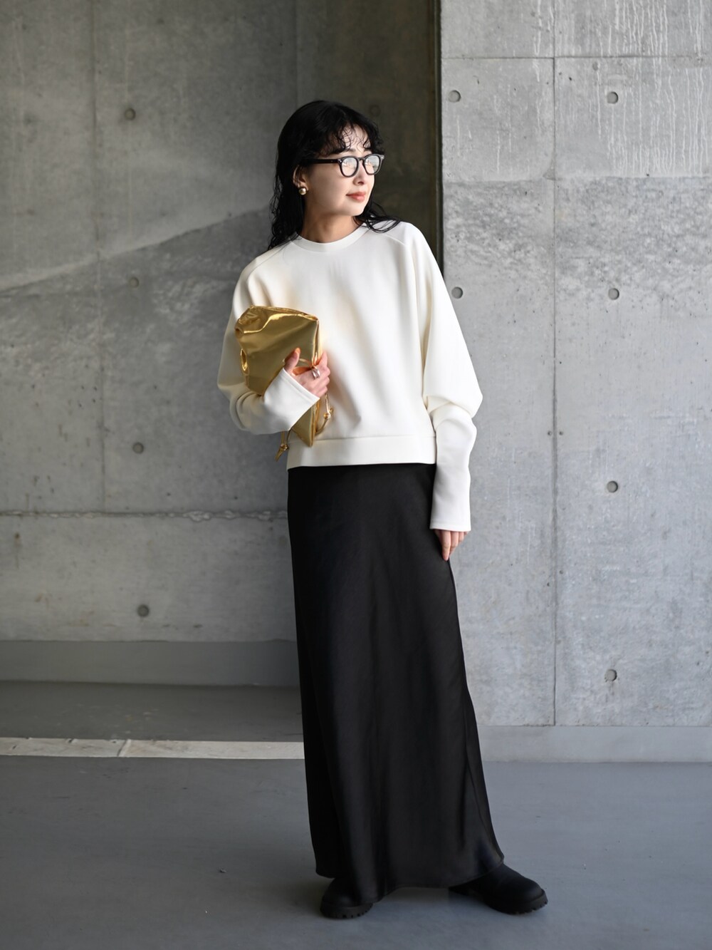 ホワイト系のスウェット、ブラック系のスカート、ゴールド系のショルダーバッグを着用したレディースの春コーディネートの4枚目の写真