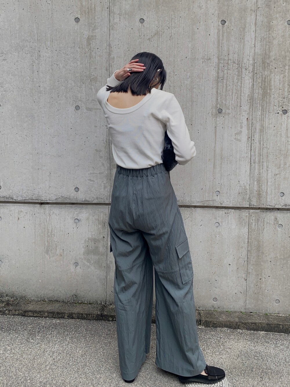 グリーン系のカーゴパンツ、ホワイト系のTシャツ/カットソー、シルバー系のネックレスを着用したレディースの冬コーディネートの2枚目の写真