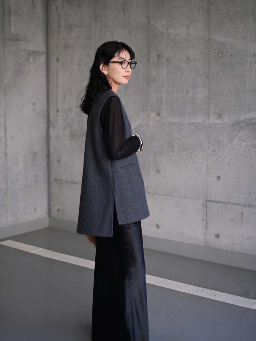 グレー系のベスト、ブラック系のTシャツ/カットソー、ブラック系のスカートを着用したレディースの秋コーディネートの4枚目の写真