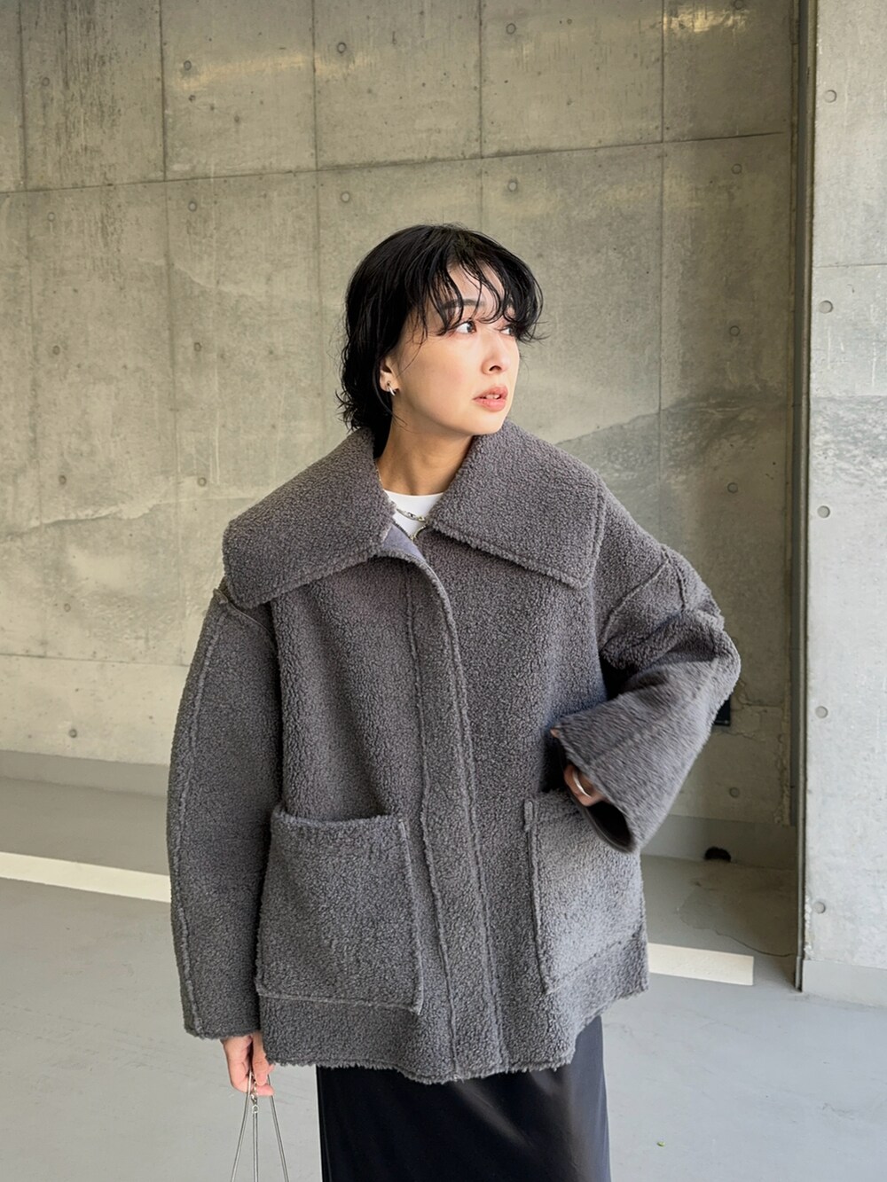 グレー系のその他アウター、シルバー系のショルダーバッグ、ブラック系のスカートを着用したレディースの冬コーディネートの3枚目の写真