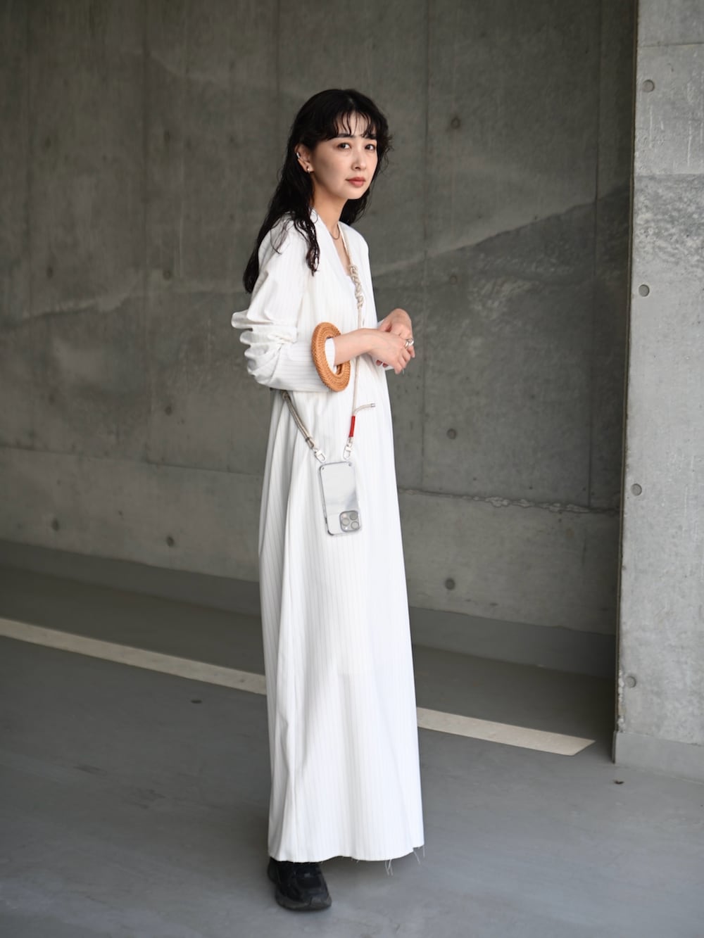 ホワイト系のワンピース、ブラック系のスニーカー、ブラック系のキャミソールを着用したレディースの春コーディネートの5枚目の写真