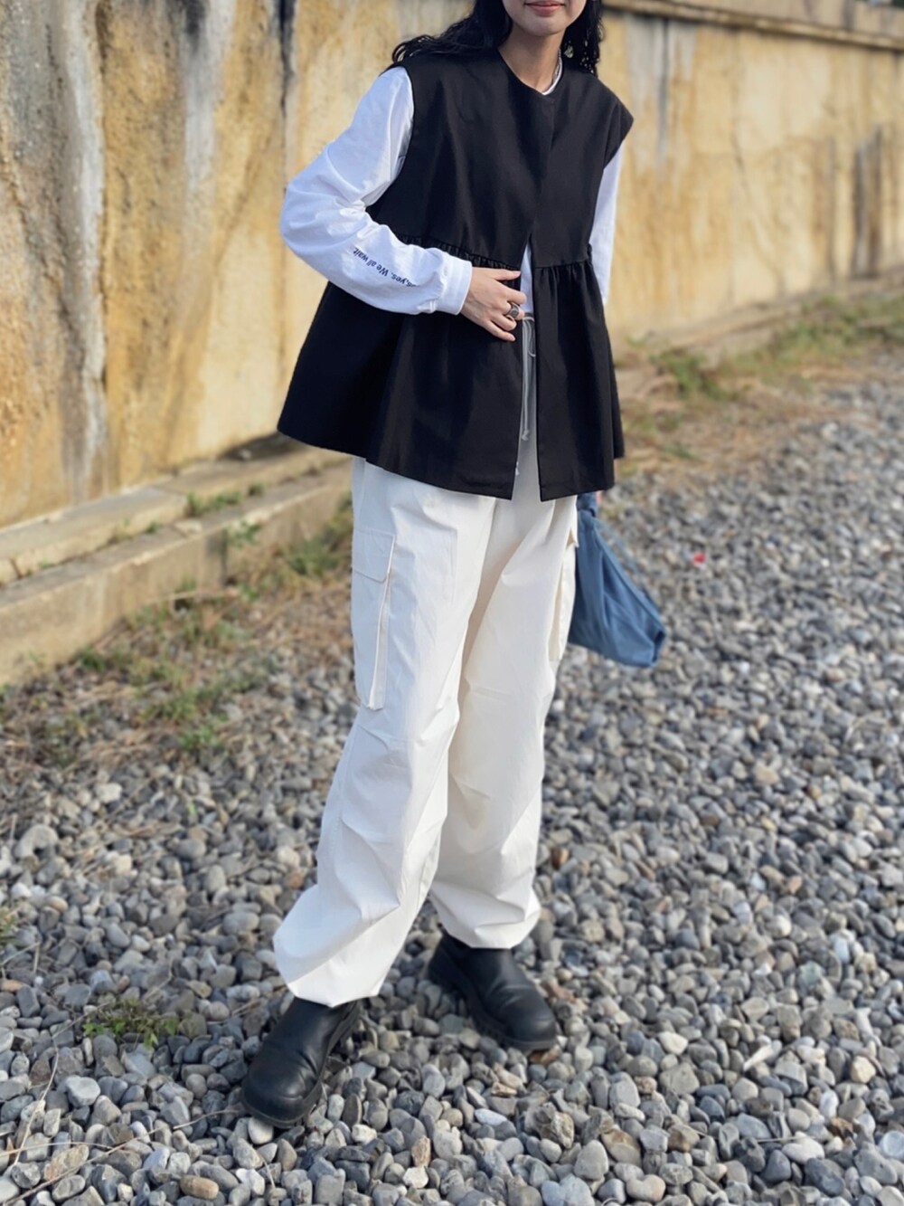 ホワイト系のTシャツ/カットソー、ホワイト系のカーゴパンツ、ブラック系のその他アウターを着用したレディースの秋コーディネートの3枚目の写真