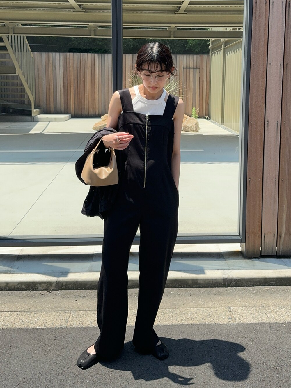 ブラック系のサロペット/オーバーオール、ホワイト系のタンクトップ、ブラック系のバレエシューズを着用したレディースの夏コーディネートの2枚目の写真