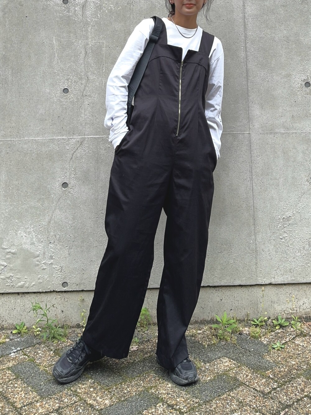 ブラック系のサロペット/オーバーオール、ブラック系のショルダーバッグ、ブラック系のスニーカーを着用したレディースの夏コーディネートの2枚目の写真