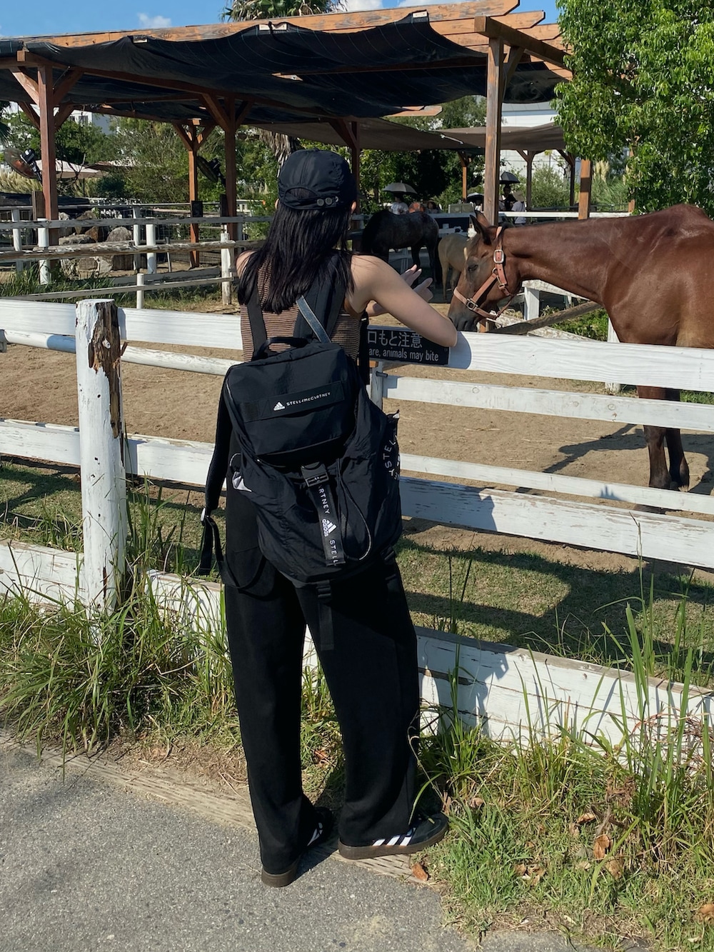 ブラック系のサロペット/オーバーオール、ブラック系のバックパック/リュック、ブラック系のスニーカーを着用したレディースの夏コーディネートの3枚目の写真